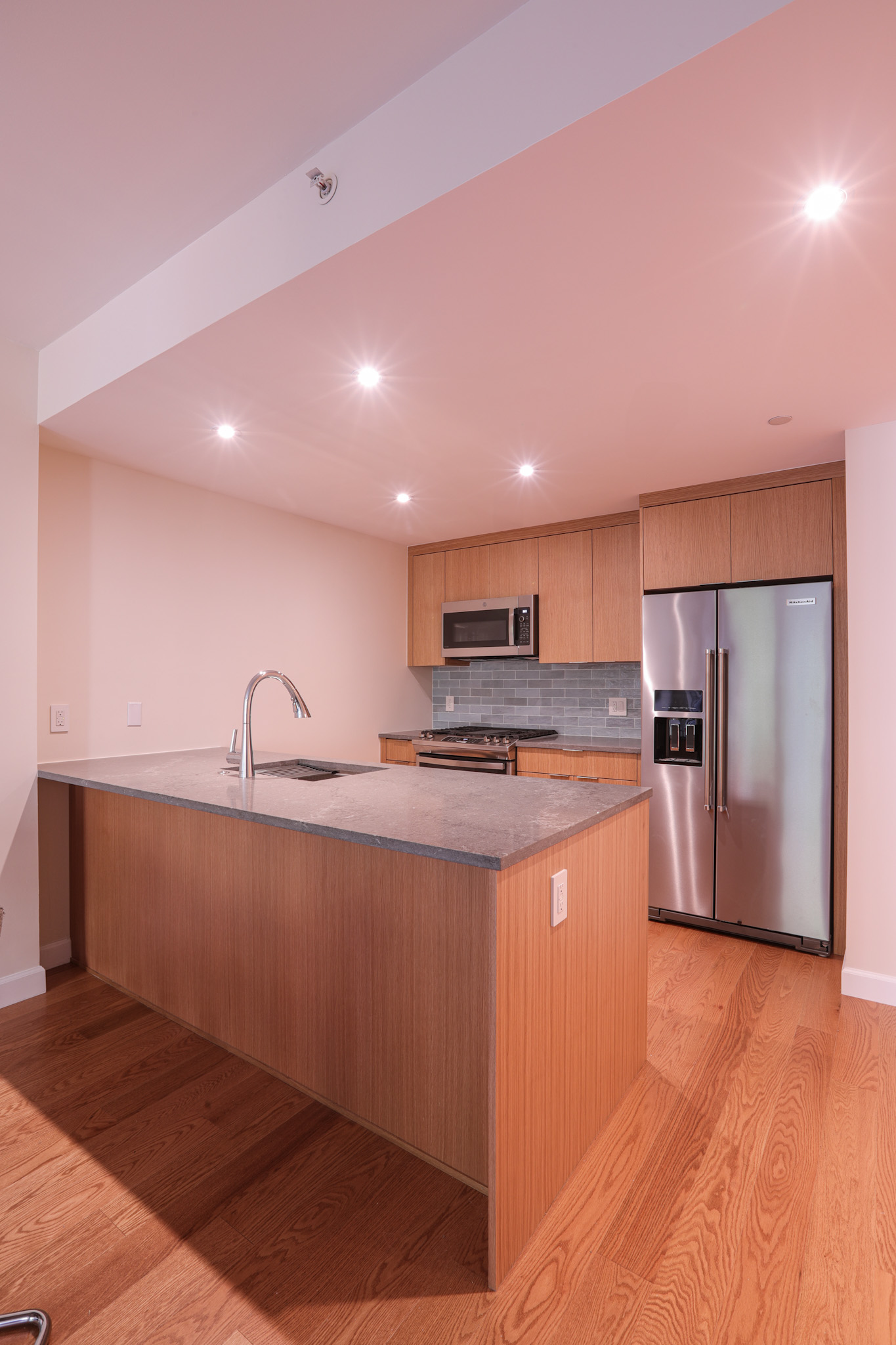 Open kitchen with island and light oak flat-panel cabinetry